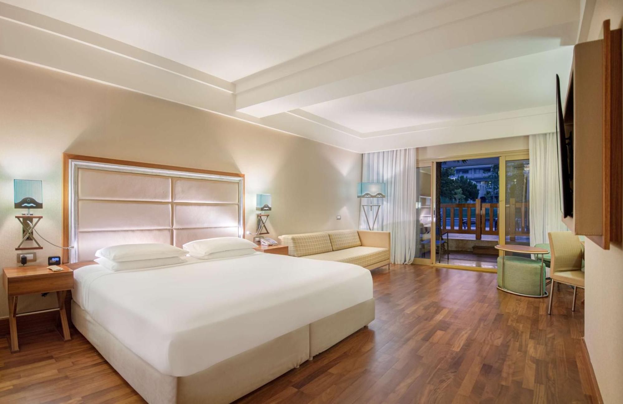 Deluxe Zimmer mit Kingsize-Bett und Poolblick.
